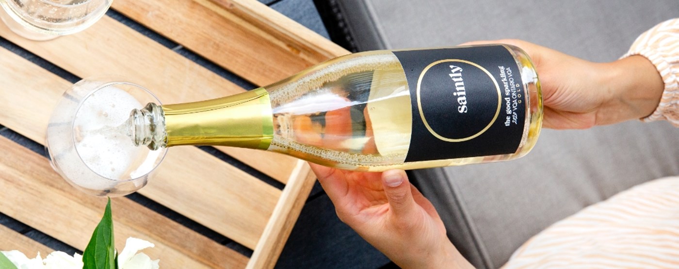 Bottle of Saintly sparkling wine being poured into a glass