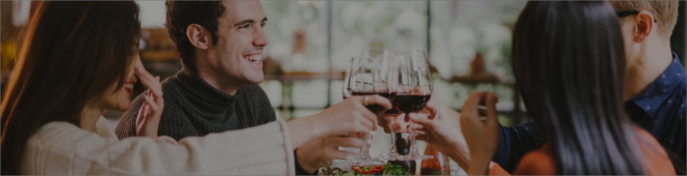 Friends celebrating with a glass of red wine.