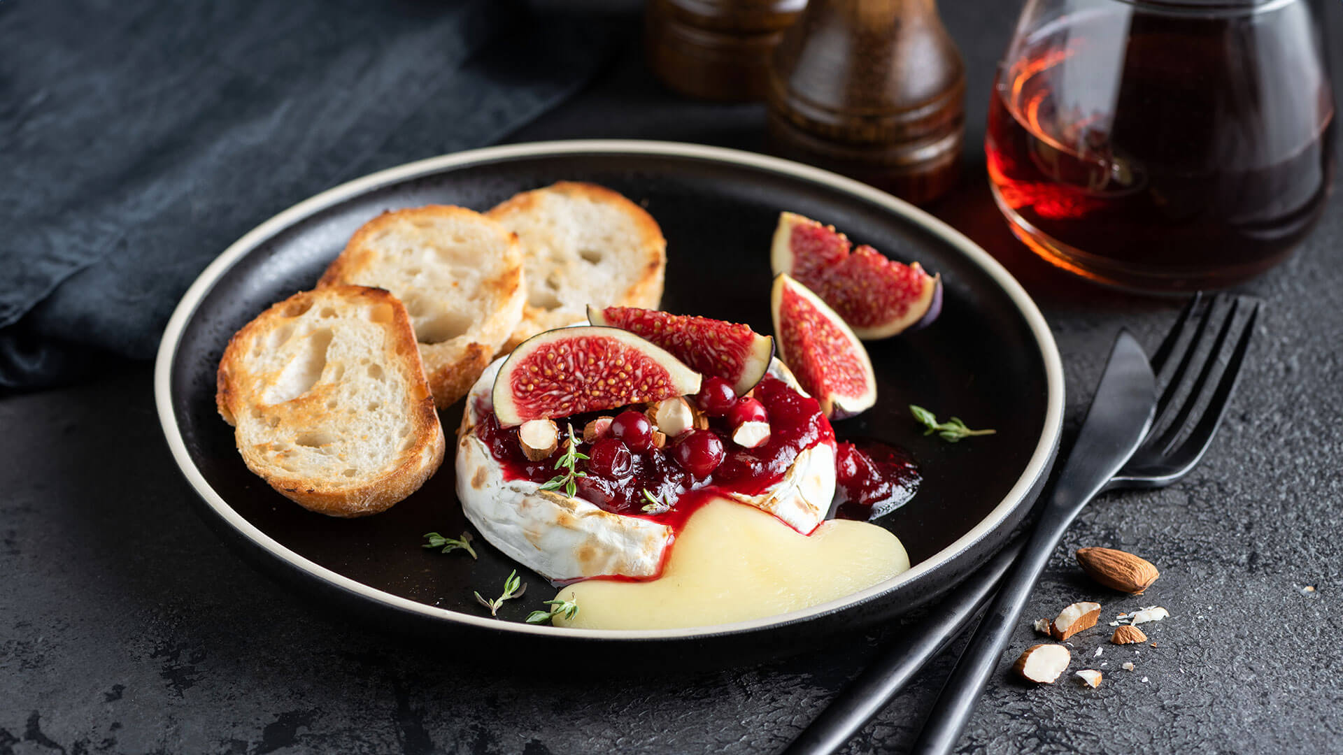 Red Pepper Jelly Baked Brie Recipe with Figs, Cranberry and mini toast paired with red wine. 