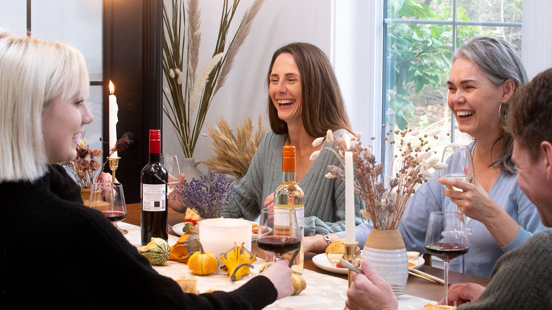 Friends and family gathered for dinner enjoying red and white wine 