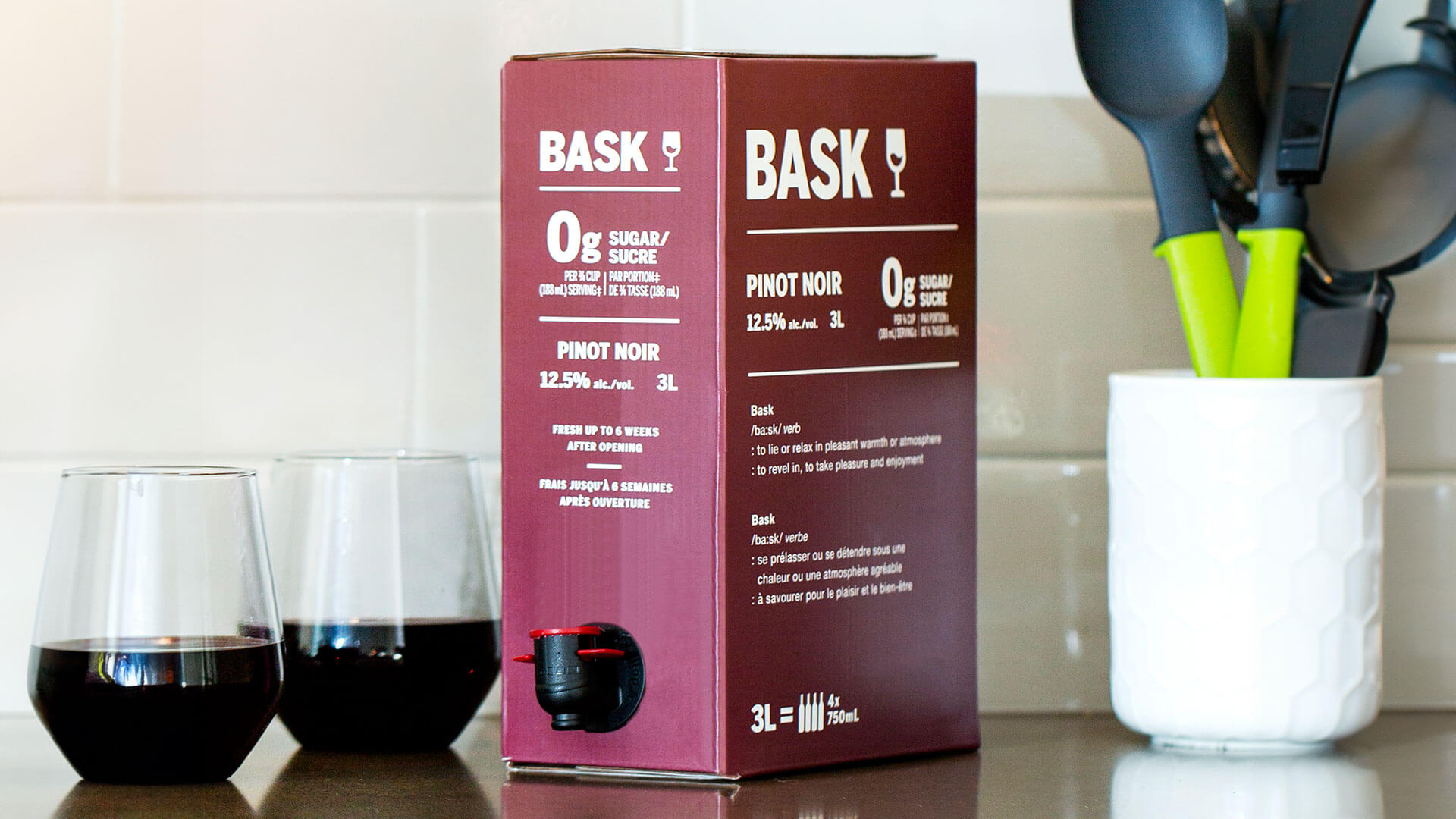 Bask Pinot Noir 3L box with red wine glasses on kitchen counter.