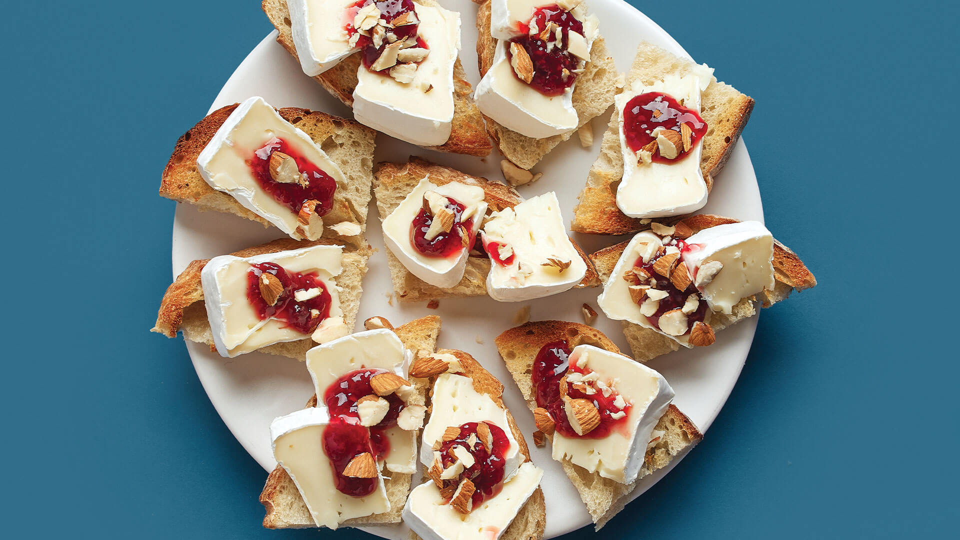 A delicious tray of crostini paired with brie cheese and spicy pepper jelly.