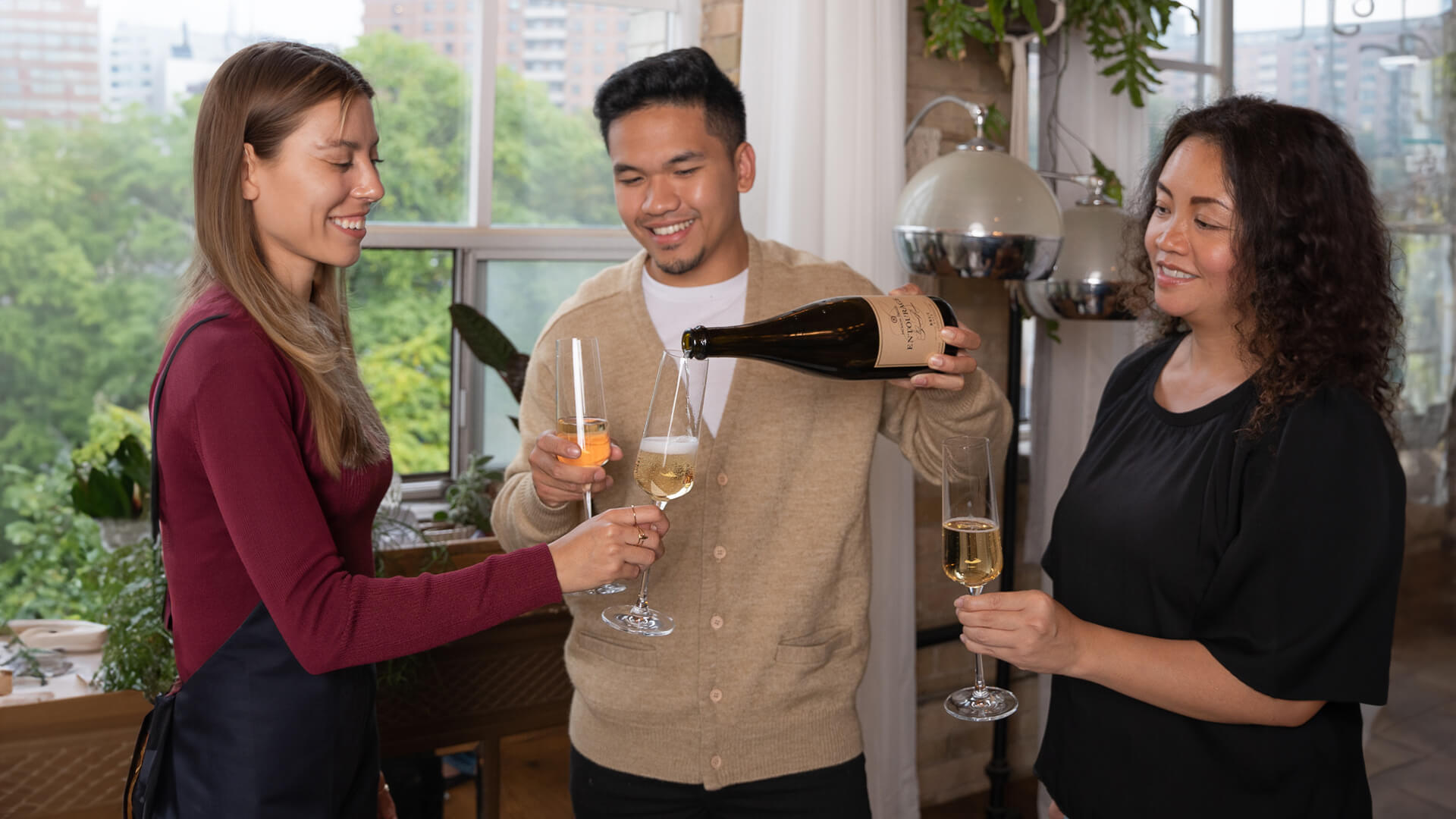 Wine lovers pouring a glass of Jackson-Triggs Entourage Grand Reserve Brut Sparkling Wine.