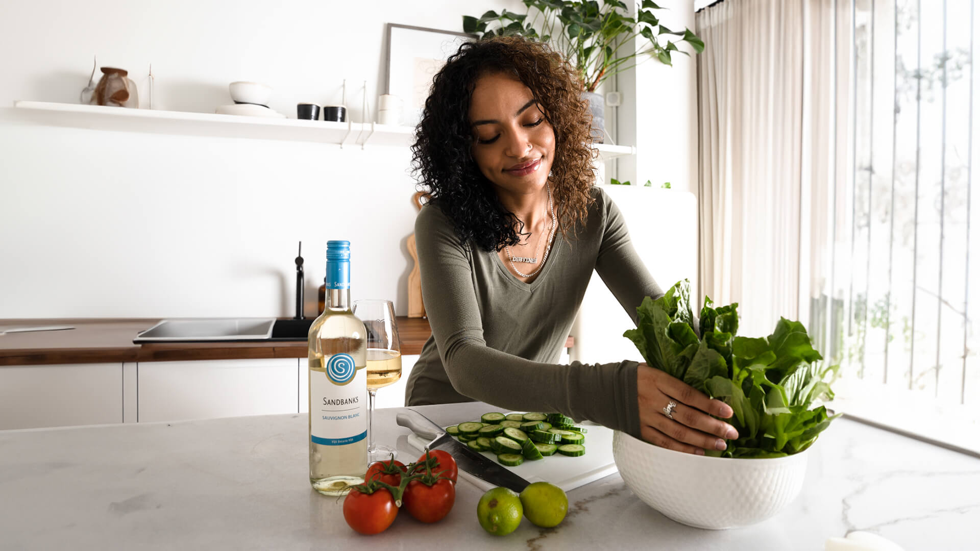 A bottle of Sandbanks on the counter with a prepared salad.